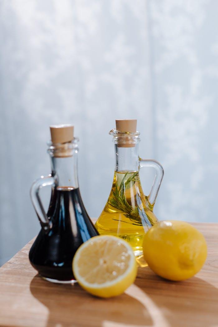 our-story Halved lemon with Italian olive oil and balsamic vinegar set on a wooden surface.